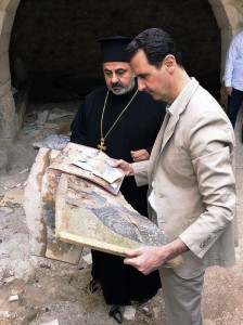 In this photo released by the Syrian official news agency SANA, Syrian President Bashar Assad, right, holds a broken religious mosaic during his visit to the Christian village of Maaloula, near Damascus, Syria, Sunday April, 20, 2014. Assad toured a historic Christian village his forces recently captured from rebels, state media said, as the country's Greek Orthodox Patriarch vowed that Christians in the war-ravaged country "will not submit and yield" to extremists. The rebels, including fighters from the al-Qaida-affiliated Nusra Front, took Maaloula several times late last year.