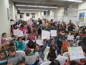 Children holding up their coloring books.