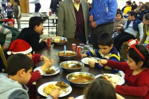 Islam Ghatas and William Murray with children at a Christmas for Refugee event